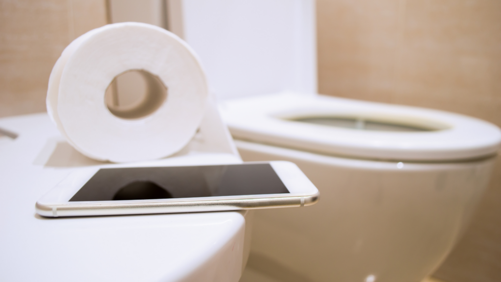 Phone use on the toilet stock image
